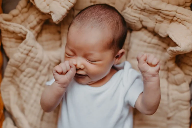 Selecting Open Adoption: Cherishing the moment of a closeup newborn stretching arms. Embrace the journey with informed choices.
