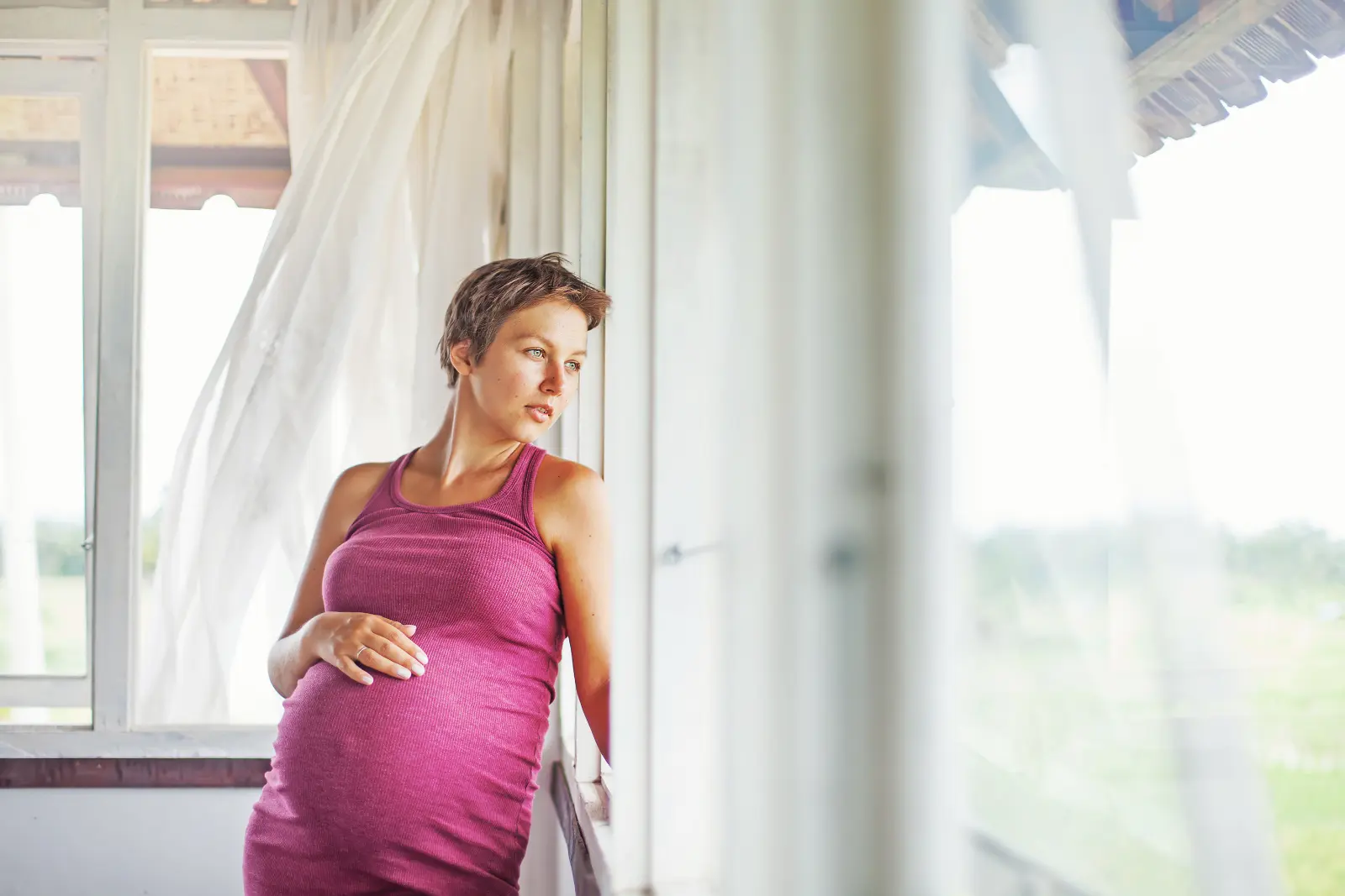 Post-Adoption Birth Mothers. A pregnant woman looking outside