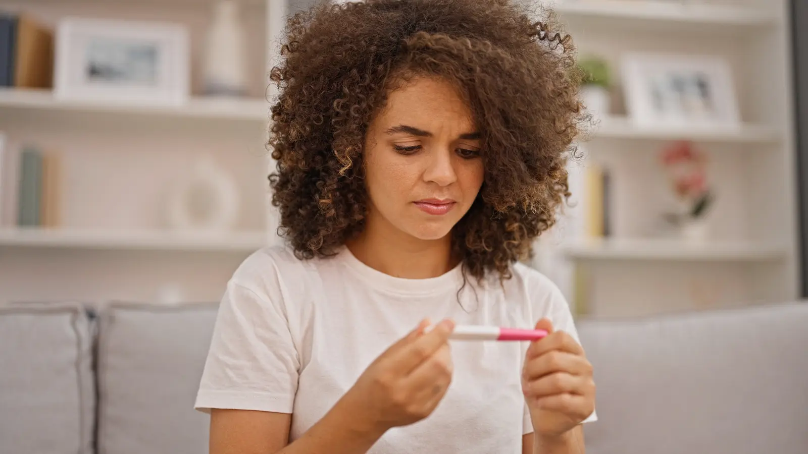 Post-Adoption Counseling a woman looking at pregnancy test with serious expression